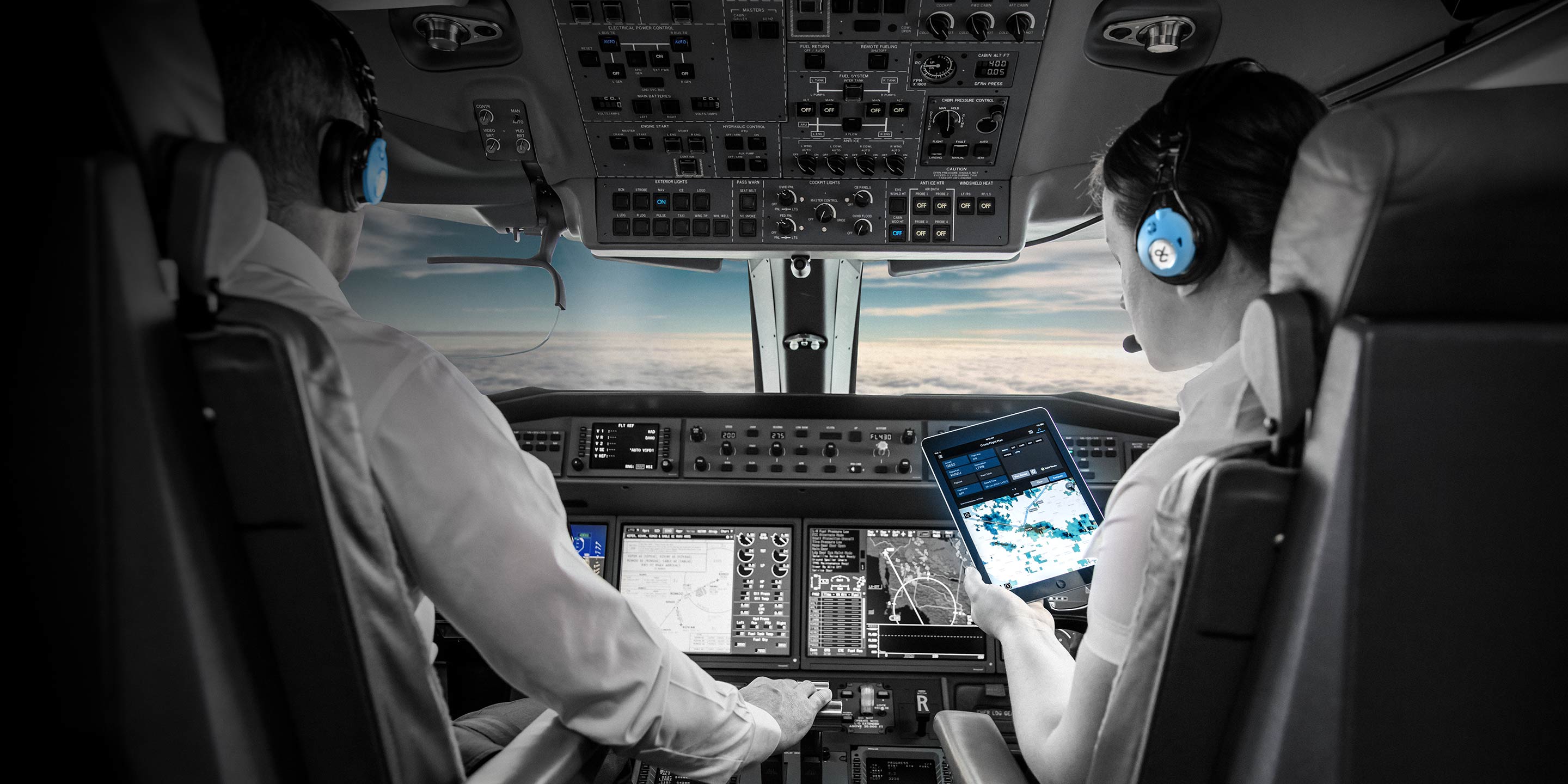 Pilots Monitoring Avionics and Flight Controls in Aircraft Cockpit Commercial pilots monitoring avionics and flight controls inside aircraft cockpit during flight.