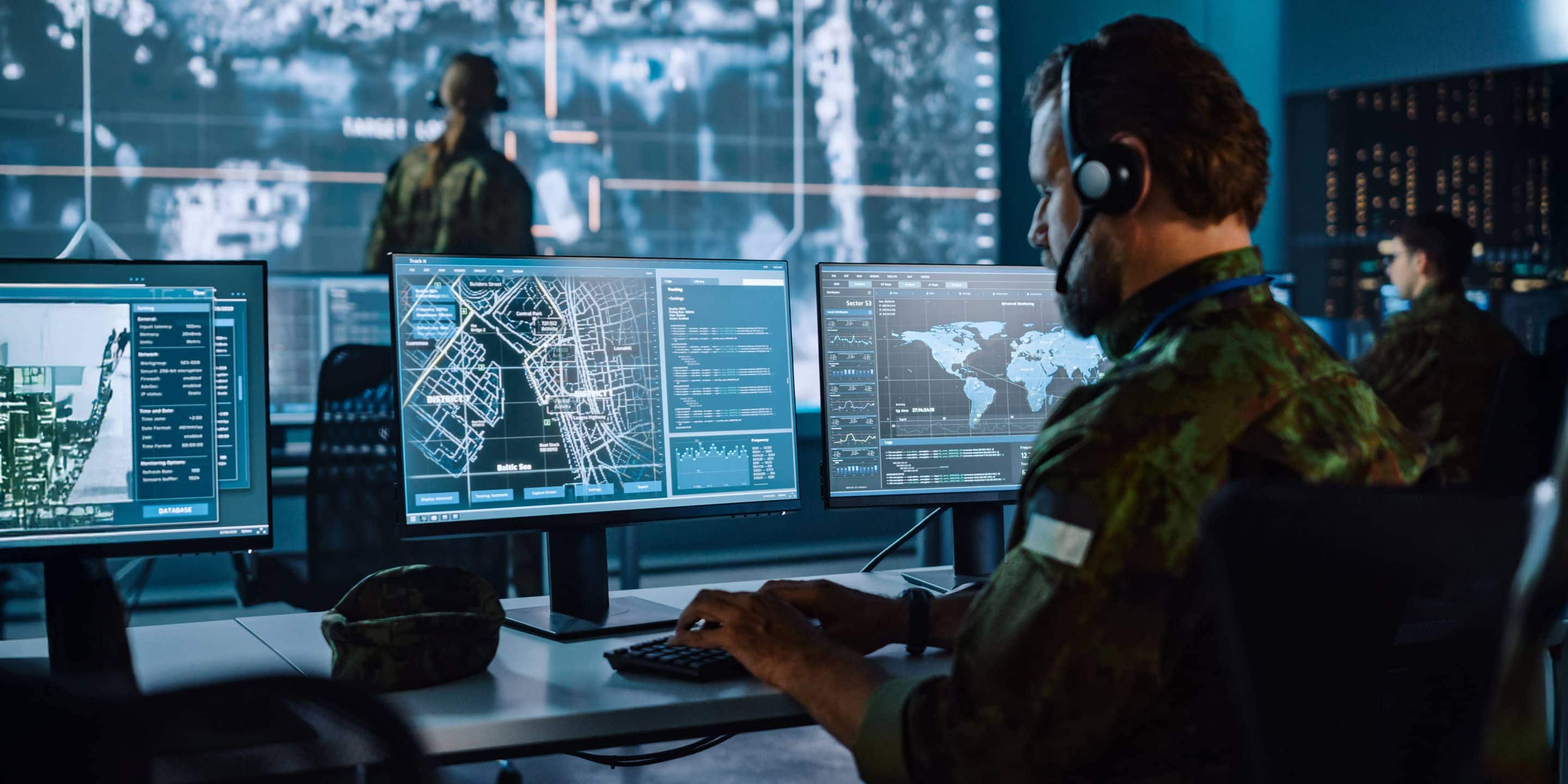 Cyber defense specialist observing network activity on multiple displays Cyber defense specialist observing network activity on multiple displays